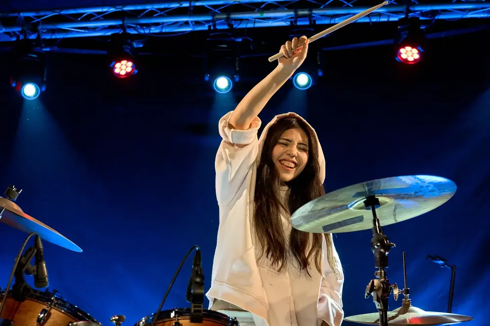 Alumna aixecant les baquetes en un concert de Jambala